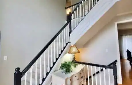 Staircase with black painted handrail and white spindles