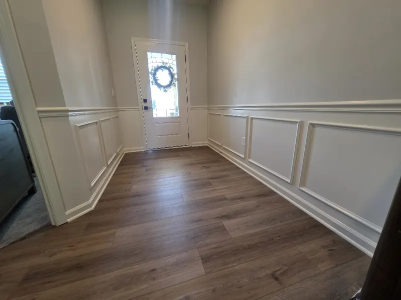 Entry hall looking toward the front door with white box moulding and chair rail on both walls