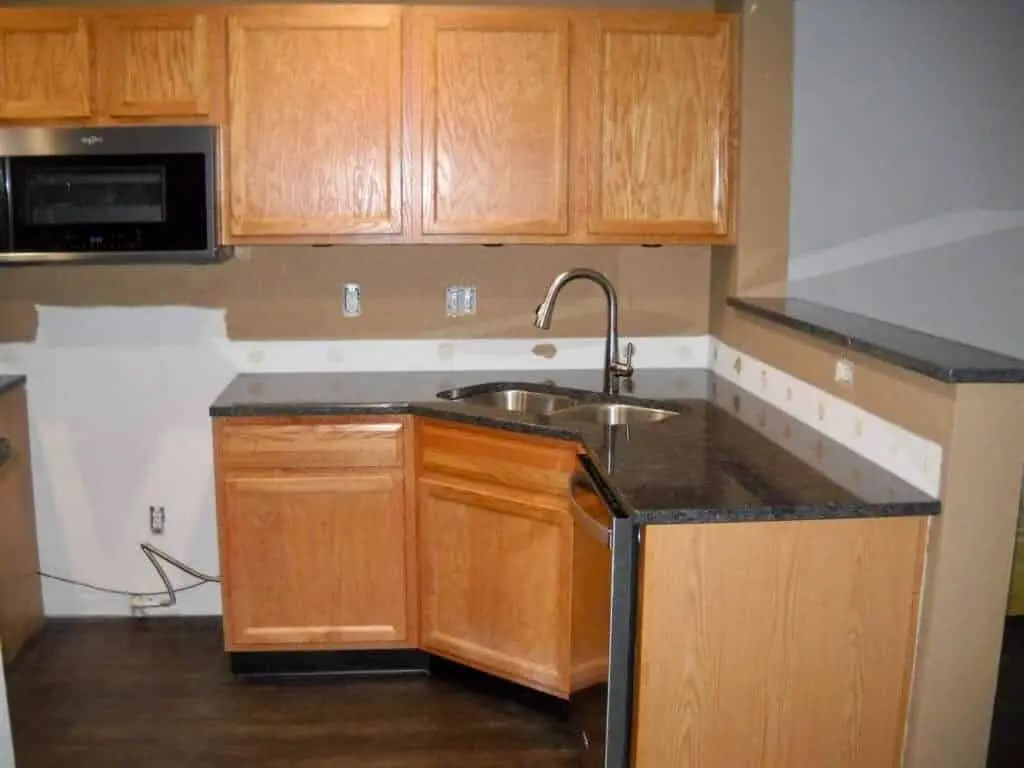 Honey oak kitchen cabinets with the hardware removed, sanded and filled before painting