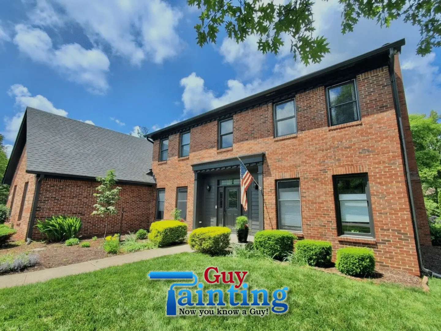 Red and brown brick home with windows, gutters and front entry painted black (Sherwin-Williams Iron Ore)