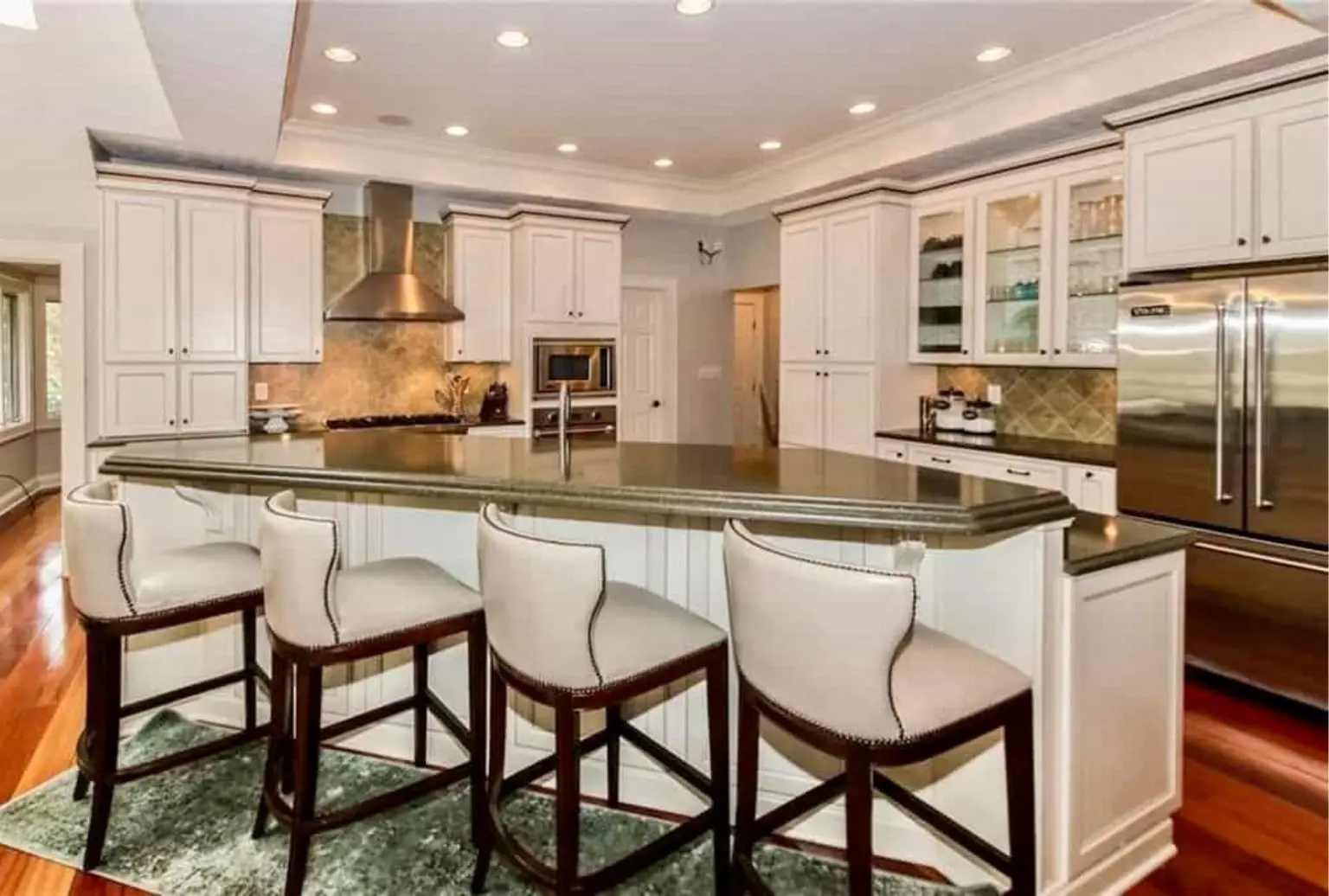 Before: Geist kitchen with Gauntlet Gray cabinets, an angled island and dark countertops