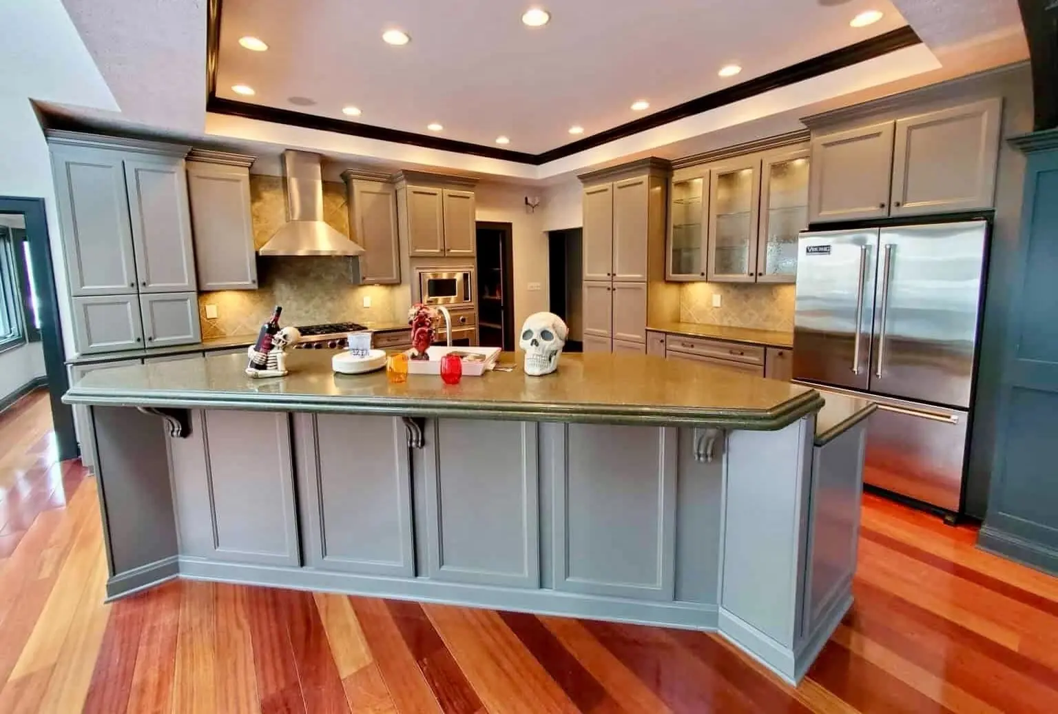 After: kitchen cabinets and angled island painted Gauntlet Gray, above glossy hardwood floors