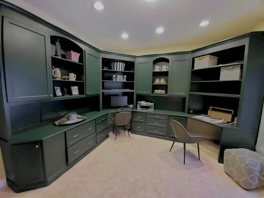 Wrap-around built-in desk and shelving in a home office, painted forest green
