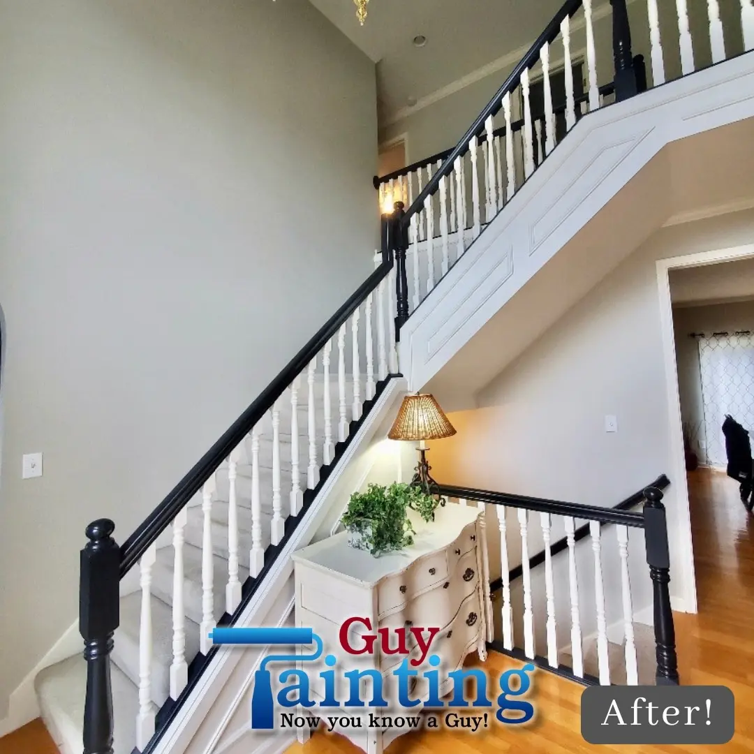 After: foyer staircase with a black-painted banister and white spindles
