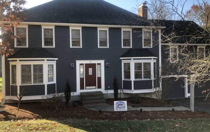 Two-story home with dark grey siding and white trim.