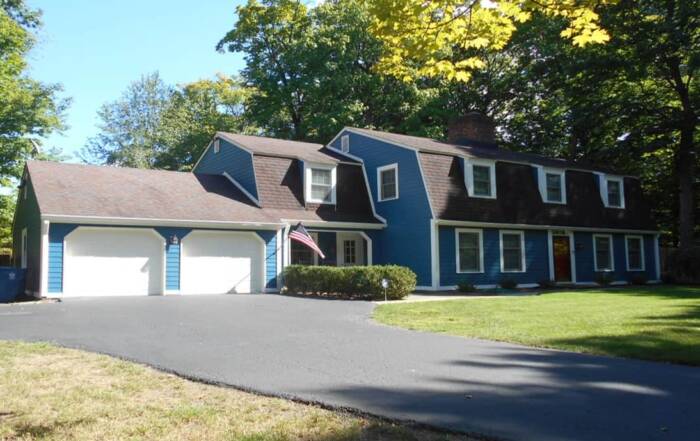 Two-story residence in Geist with bold blue lap siding and crisp white trim.
