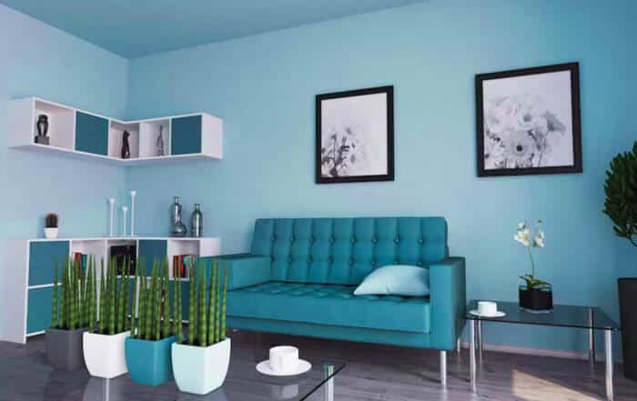 Living room with vibrant teal walls and matching tufted sofa.